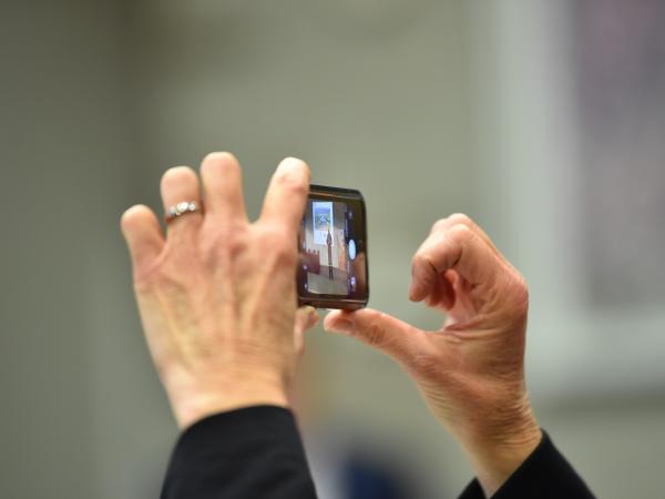 someone holding up a phone to film