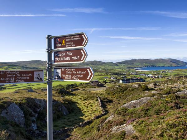 Sign post for Mountain trail with view of mountains and sea in background