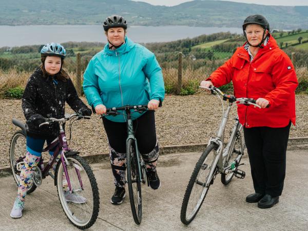 from left to right Erin, Noreen and Mary all pose with their bikes