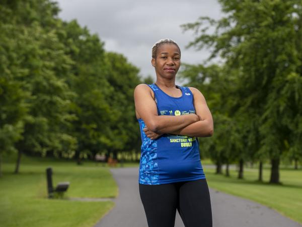 Amara Onwuzulumba stands in running gear looking at the camera with arms folded