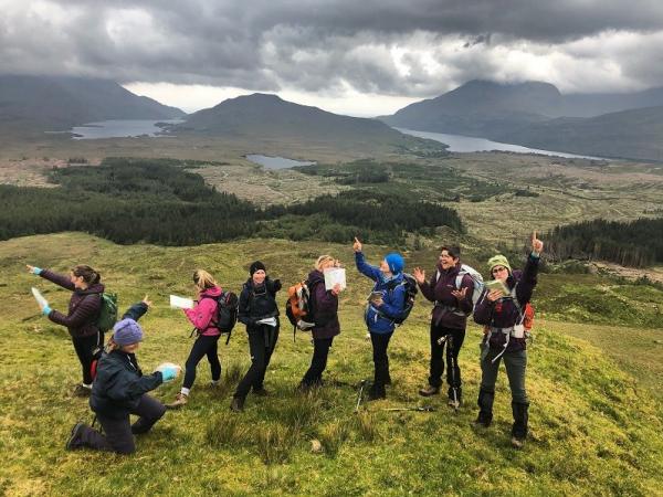 HER Outdoors Mountaineering Ireland - Women map reading at the top of a mountain