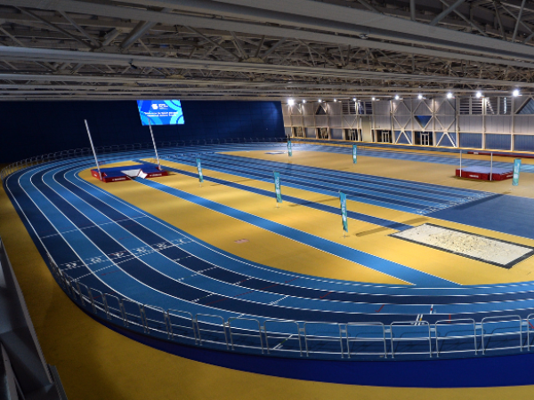Indoor athletics track with blue lanes and yellow infield at the Sport Ireland Campus