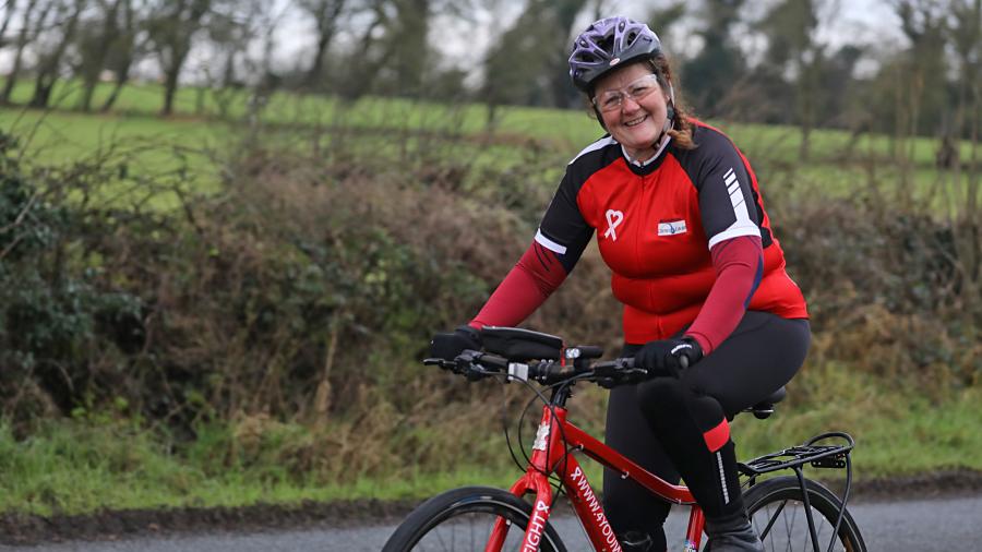 A lady, 48 years old cycling her bike from the right hand side of the image