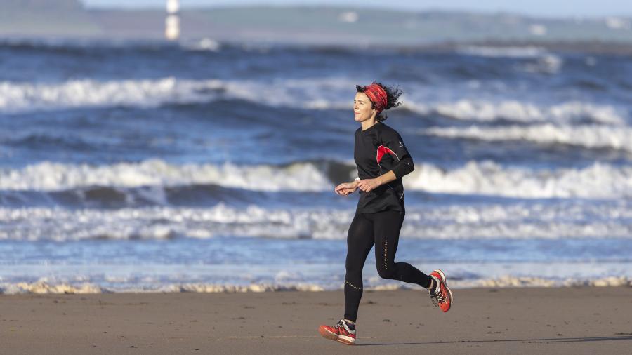 Female runs along a beach