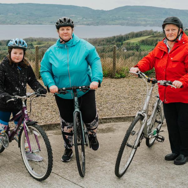 from left to right Erin, Noreen and Mary all pose with their bikes