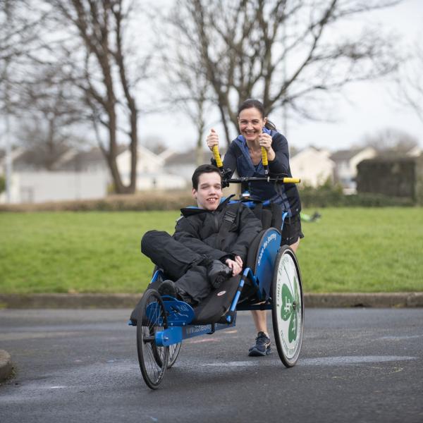 Sinead runs in a park pushing her son Daniel in an adapted wheelchair