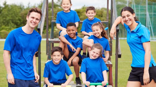 Group of children pose with a male and female coach