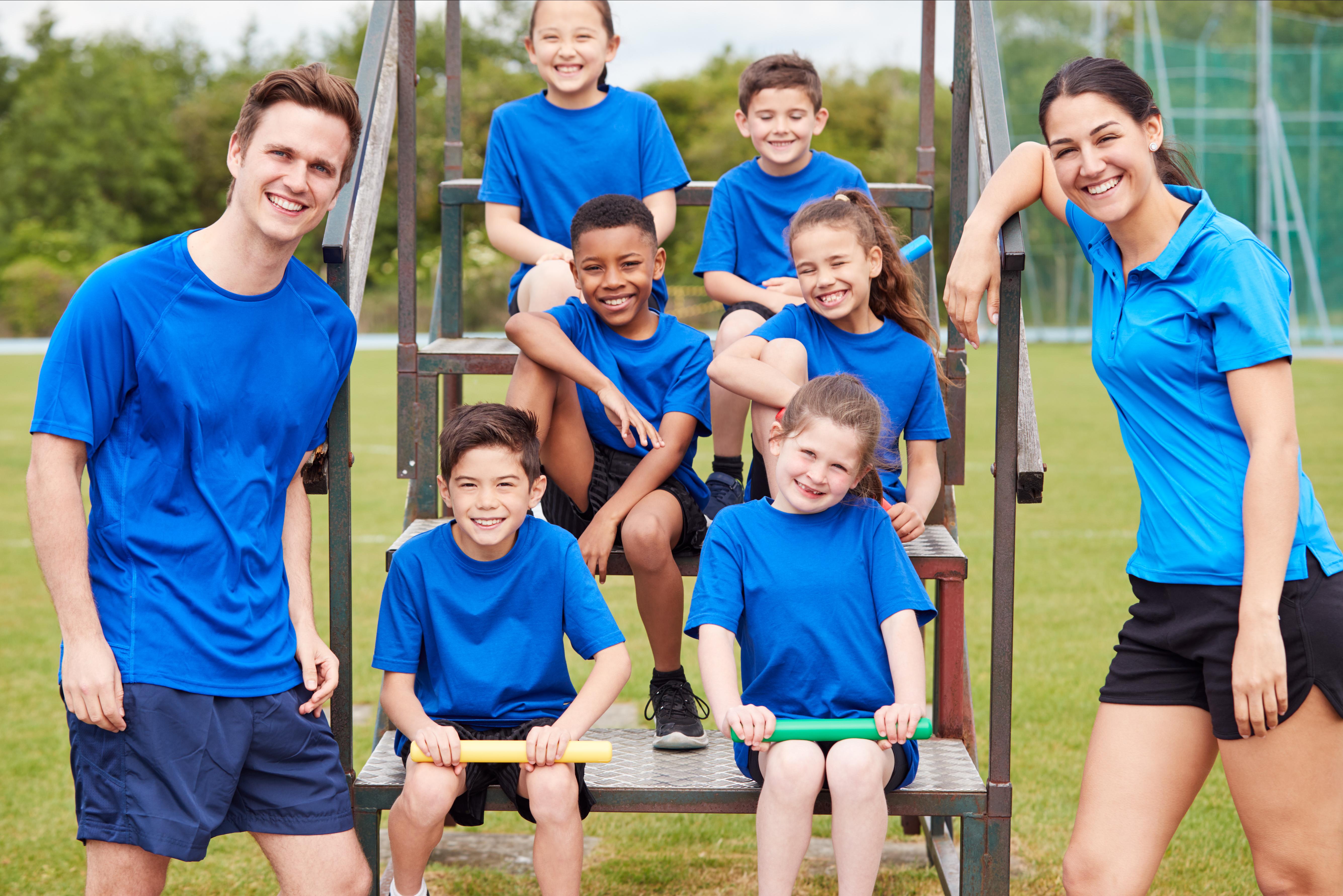 Group of children pose with a male and female coach