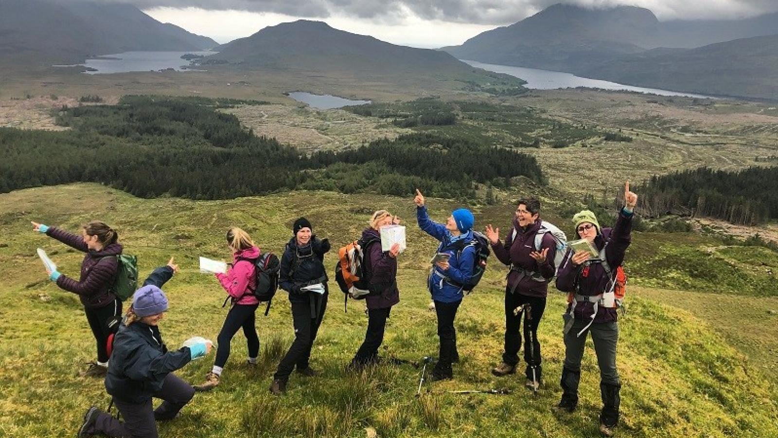HER Outdoors Mountaineering Ireland - Women map reading at the top of a mountain