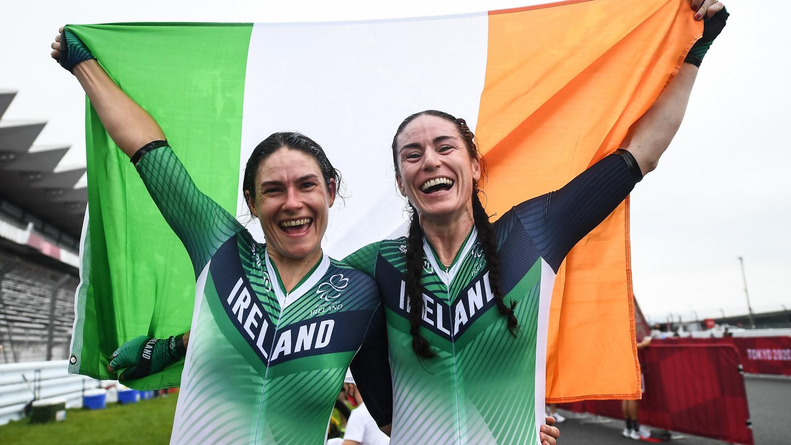Katie George Dunlevy and Eve McCyrstlal cheer and hold the Irish flag to celebrate their gold medal