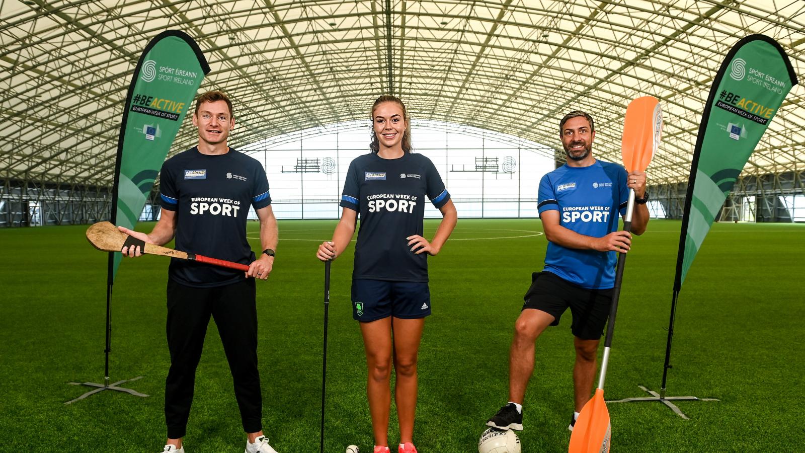David Gillick, Eimear Lambe, Kenneth Egan pose in an indoor football pitch holding various sports equipment