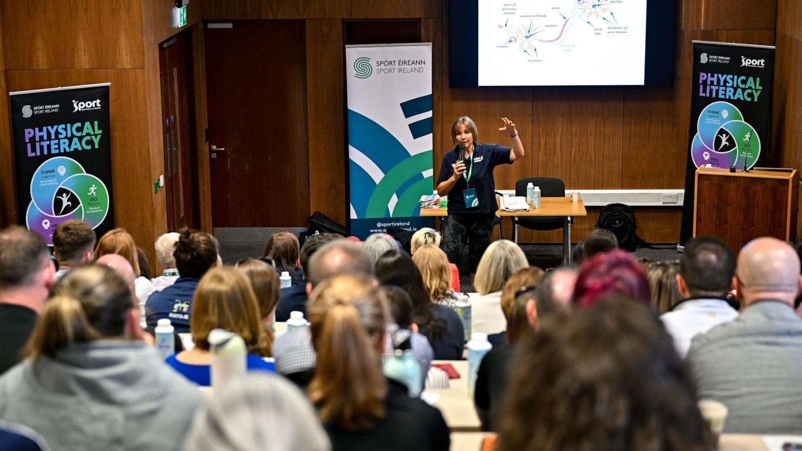 A woman in a lecture hall presenting